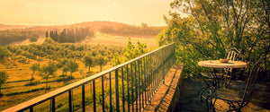 Two chairs on a balcony overlooking the Italian country side during golden hour